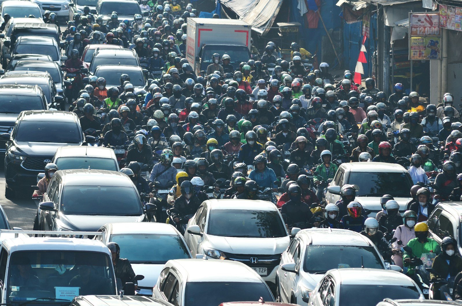 A large group of cars driving down a street